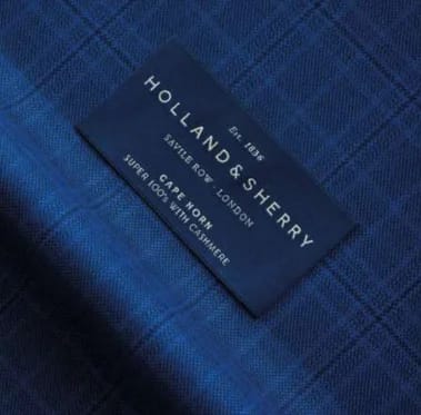 Ярлык Holland & Sherry Cape Horn Super 100's with Cashmere на синей ткани