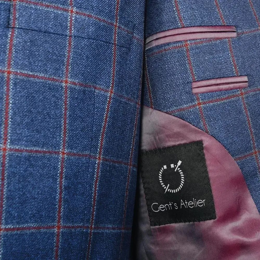 Крупный план внутреннего кармана синего пиджака в красную клетку с биркой Gent's Atelier и бордовой подкладкой
